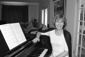 photo showing Niki Davies sat by a piano